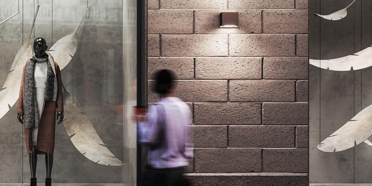 Allure by iGuzzini wallpack light on a wall outside of a store window