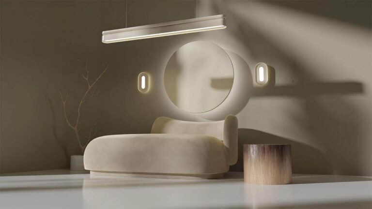 A white Nulite studio linear suspended luminaire and two Nulite Studio wall sconces installed over a modern couch