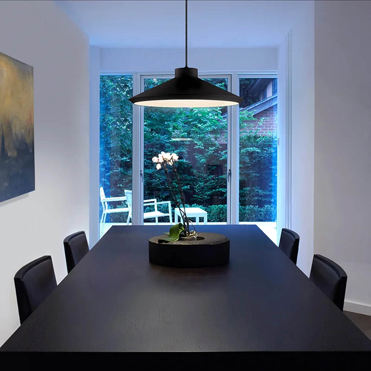 A black Sonneman Koma pendant light installed over a dining room table